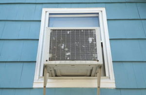 Old Air Conditioner Installed On House Window